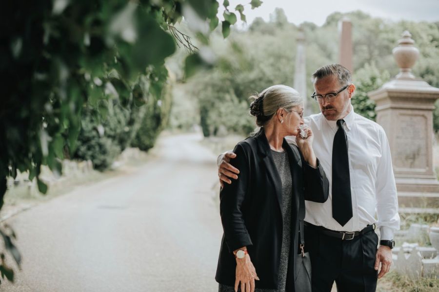 hombre y mujer saliendo de un funeral